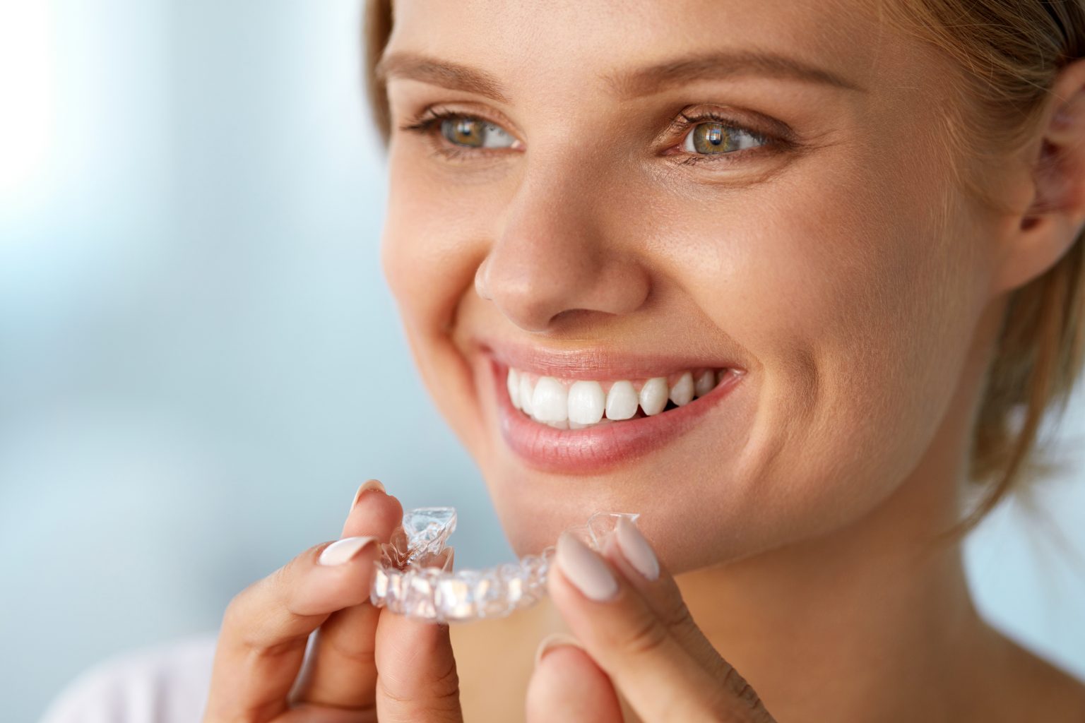 Smiling Woman With White Teeth Holding Teeth Whitening Tray. High Resolution Image